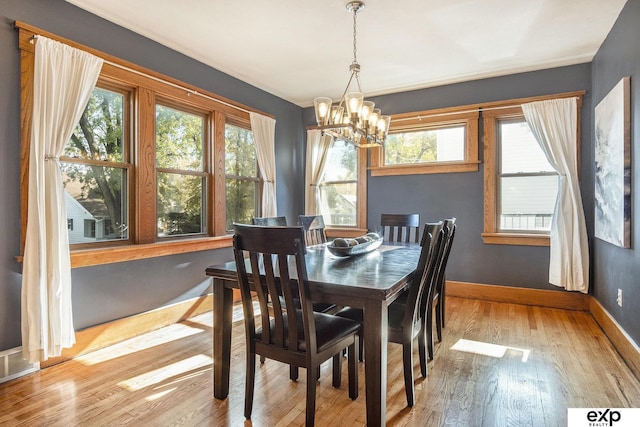 dining room with light hardwood / wood-style floors and an inviting chandelier