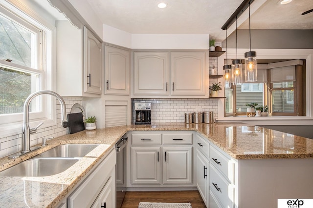 kitchen featuring sink, hanging light fixtures, white cabinets, and tasteful backsplash