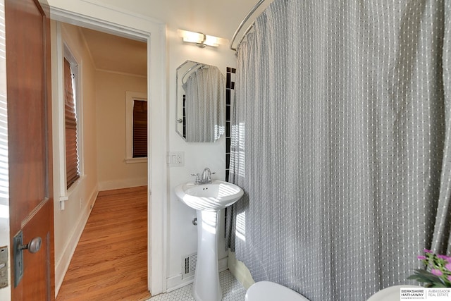 bathroom featuring hardwood / wood-style flooring, curtained shower, and sink