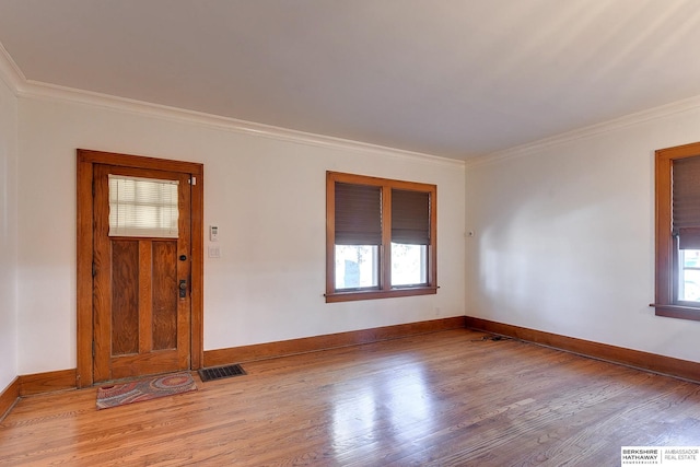 spare room with light hardwood / wood-style floors and crown molding