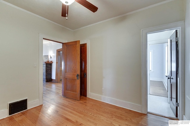 spare room with ornamental molding, ceiling fan, and light wood-type flooring