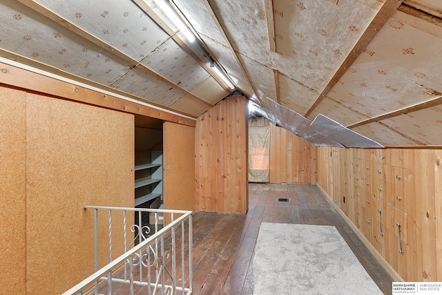 bonus room with lofted ceiling, wooden walls, and dark hardwood / wood-style floors