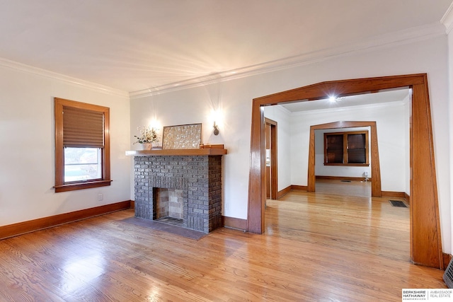 unfurnished living room with a fireplace, ornamental molding, and light wood-type flooring