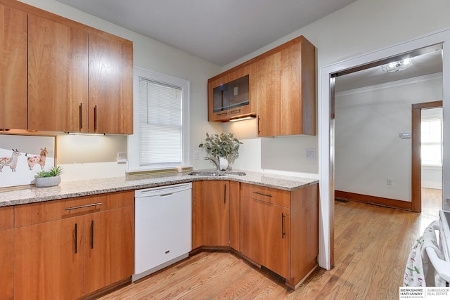 kitchen with white dishwasher, light stone countertops, light hardwood / wood-style floors, and sink