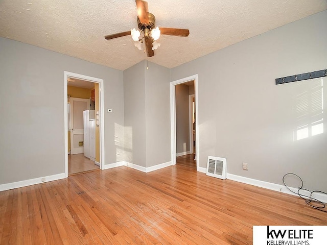 unfurnished room featuring a textured ceiling, ceiling fan, and light hardwood / wood-style floors