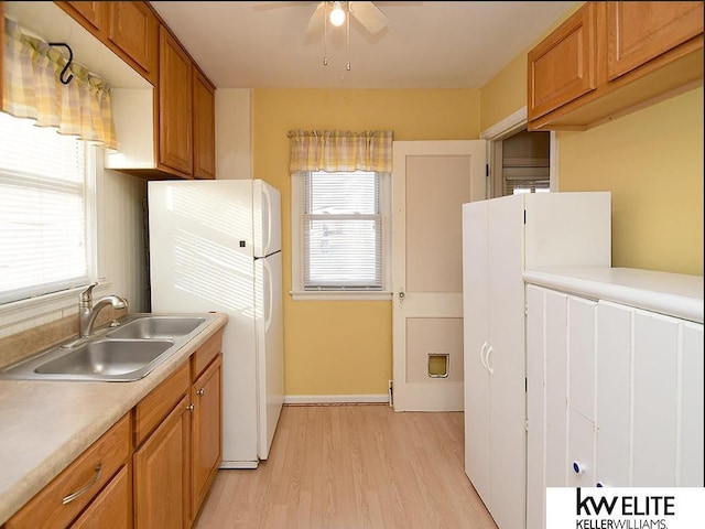 kitchen with white refrigerator, ceiling fan, light hardwood / wood-style flooring, and sink