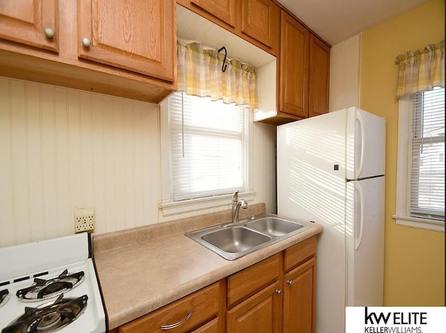 kitchen featuring sink, a healthy amount of sunlight, and white appliances