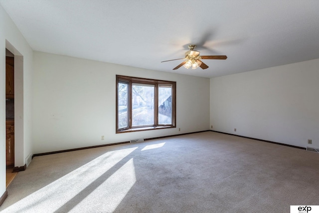 spare room with ceiling fan and light carpet