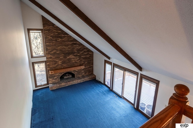 unfurnished living room with high vaulted ceiling, a fireplace, beamed ceiling, and dark carpet