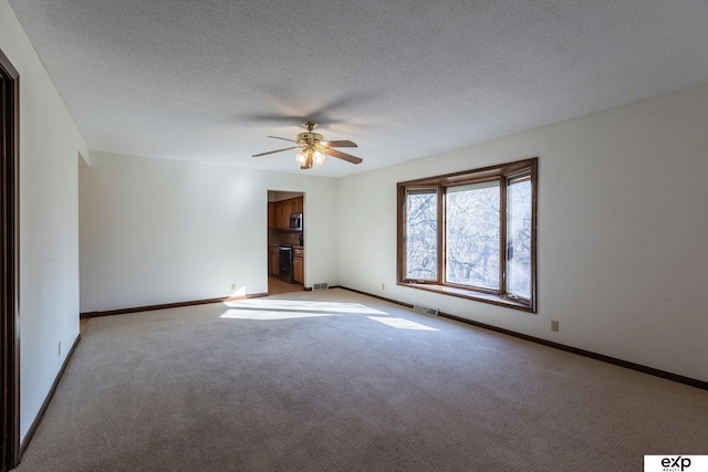 unfurnished room featuring ceiling fan, light colored carpet, and a textured ceiling