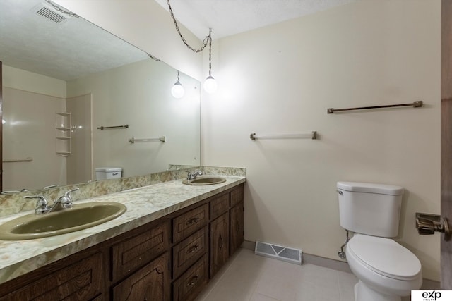 bathroom with toilet, tile patterned flooring, and vanity