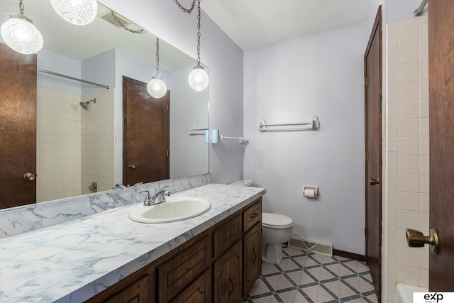 bathroom with toilet, vanity, and tile patterned flooring