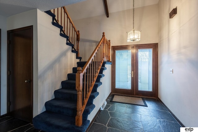 entryway with a notable chandelier, beam ceiling, and french doors