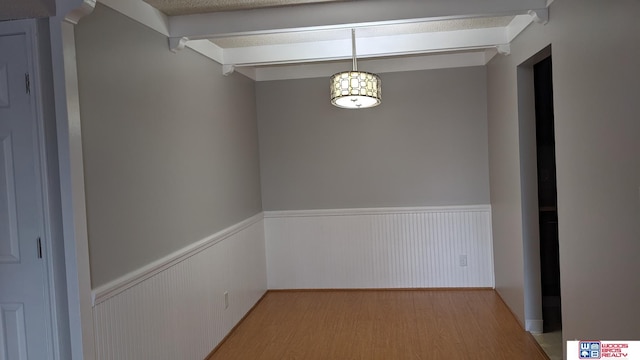 interior space featuring light wood-type flooring and beamed ceiling