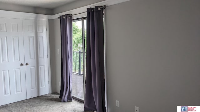 unfurnished bedroom featuring a textured ceiling, a closet, and carpet flooring