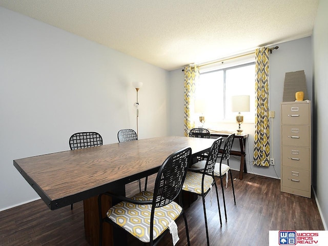 dining area featuring dark wood-type flooring and a textured ceiling