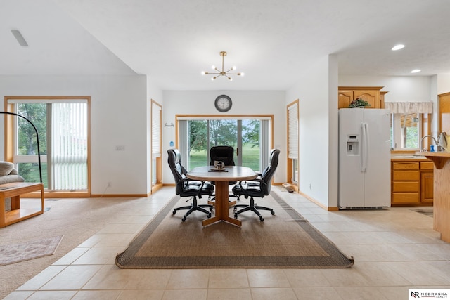 dining room featuring plenty of natural light, light tile patterned floors, sink, and a notable chandelier