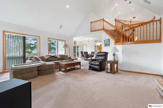 living room with high vaulted ceiling, carpet floors, and a chandelier