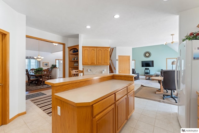 kitchen featuring lofted ceiling, white fridge, tasteful backsplash, a chandelier, and light tile patterned floors