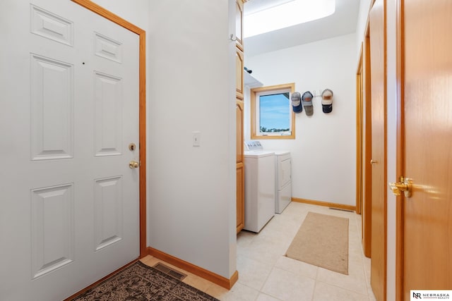 washroom with separate washer and dryer and light tile patterned floors