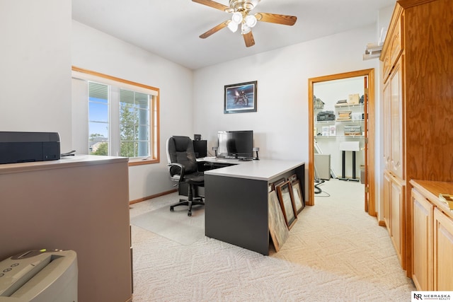 carpeted home office featuring ceiling fan