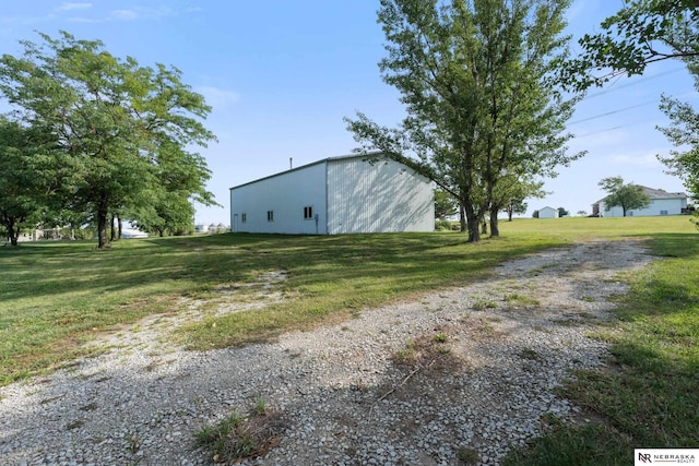 view of side of home featuring an outbuilding and a lawn