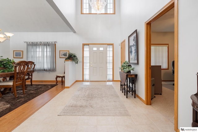 tiled foyer with a towering ceiling and an inviting chandelier