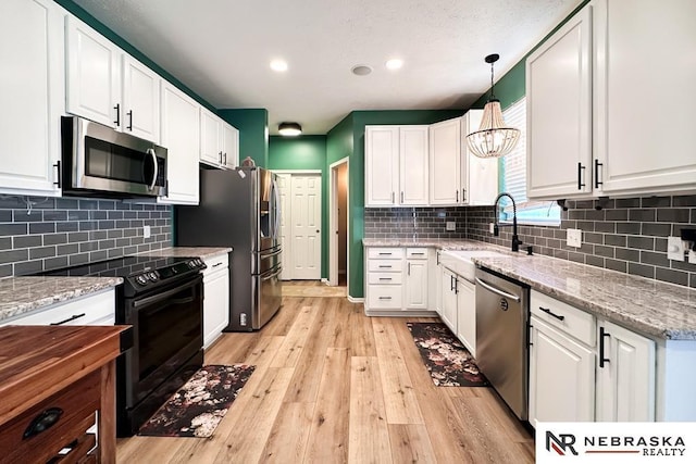 kitchen with sink, stainless steel appliances, and white cabinetry