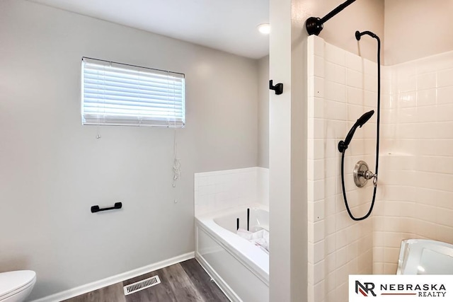 bathroom featuring hardwood / wood-style flooring, toilet, and separate shower and tub