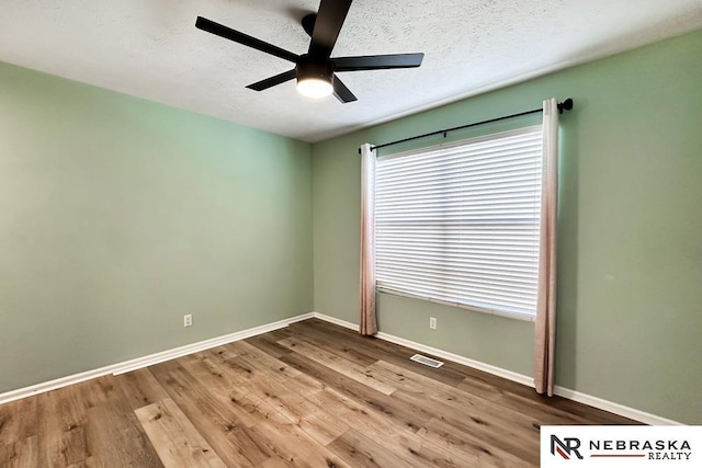 empty room featuring a textured ceiling, ceiling fan, and light hardwood / wood-style floors