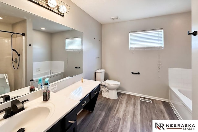 full bathroom with hardwood / wood-style floors, toilet, vanity, and independent shower and bath