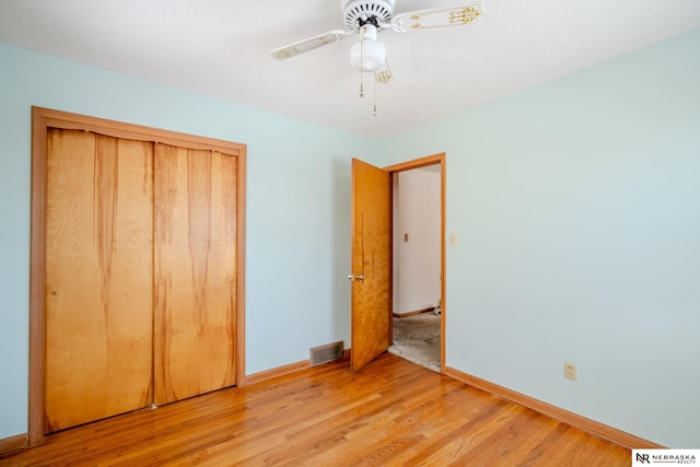 unfurnished bedroom featuring a closet, light wood-type flooring, visible vents, and baseboards