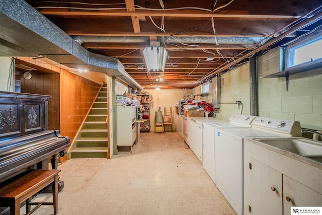 basement with stairs, light floors, washing machine and dryer, and a wealth of natural light