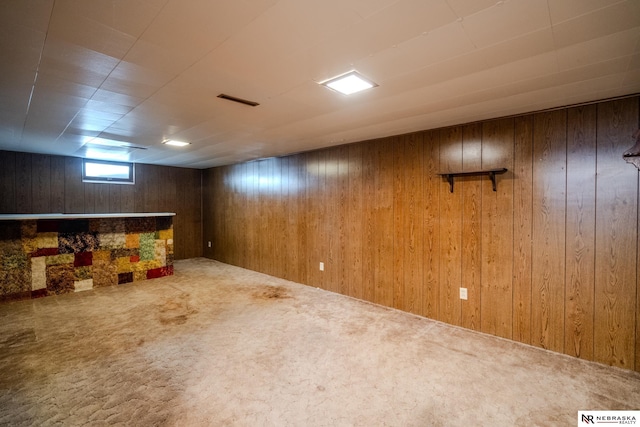 below grade area featuring carpet, visible vents, wood walls, and a dry bar