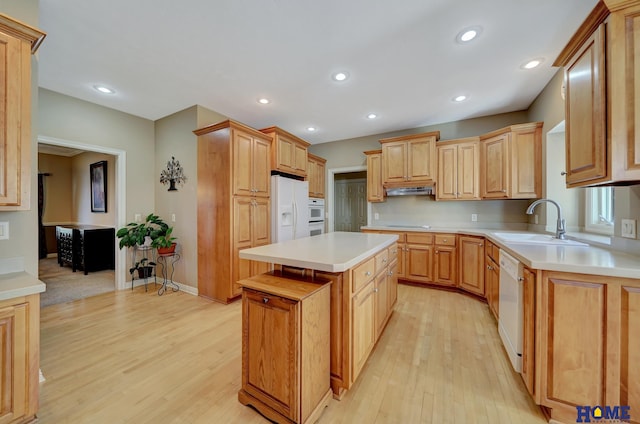 kitchen with light hardwood / wood-style floors, light brown cabinets, white appliances, a kitchen island, and sink