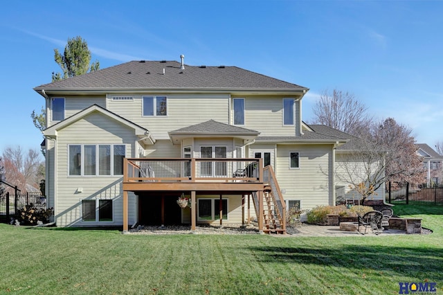 back of property featuring a wooden deck, a yard, and a fire pit