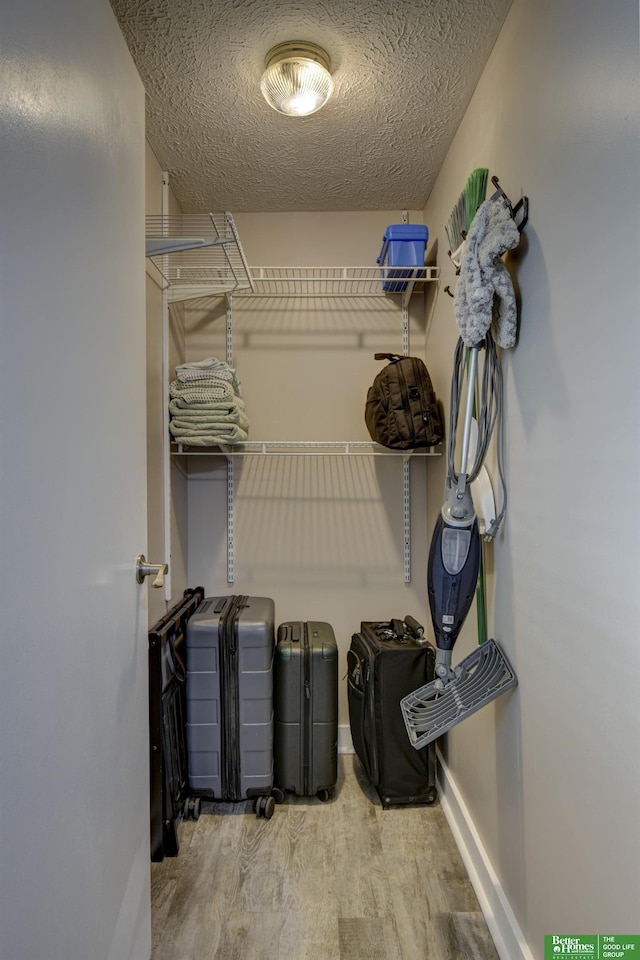 walk in closet with light hardwood / wood-style floors