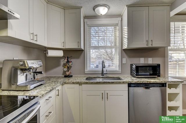 kitchen with sink, white cabinetry, a healthy amount of sunlight, stainless steel appliances, and light stone counters