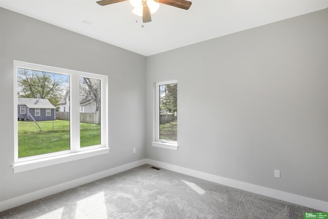 carpeted spare room featuring ceiling fan