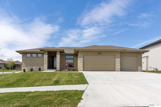 prairie-style house featuring a front lawn and a garage