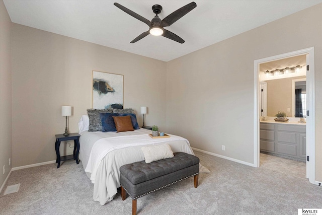 bedroom with ceiling fan, ensuite bathroom, and light colored carpet