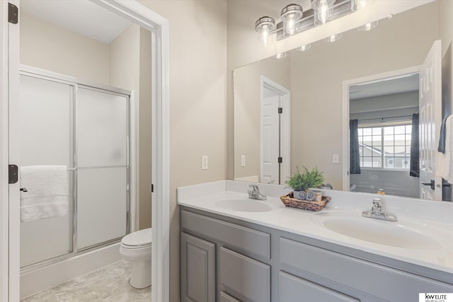 bathroom with an enclosed shower, vanity, and toilet