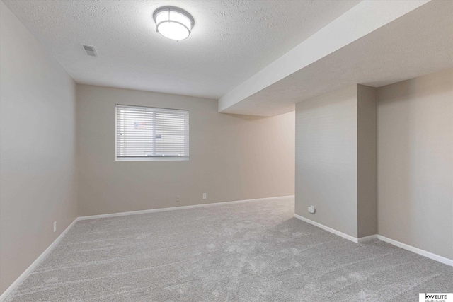 empty room featuring a textured ceiling and carpet floors