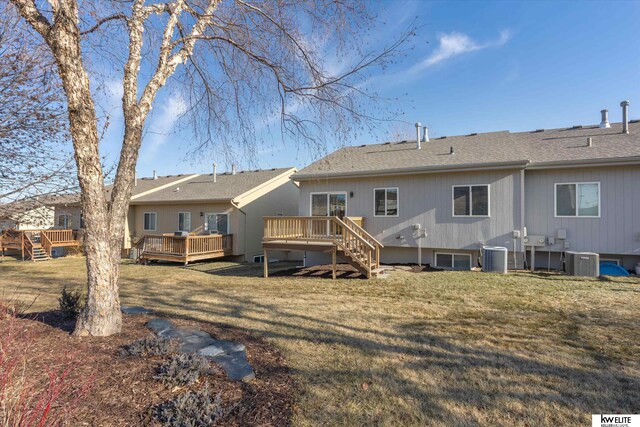 rear view of house featuring cooling unit, a yard, and a wooden deck