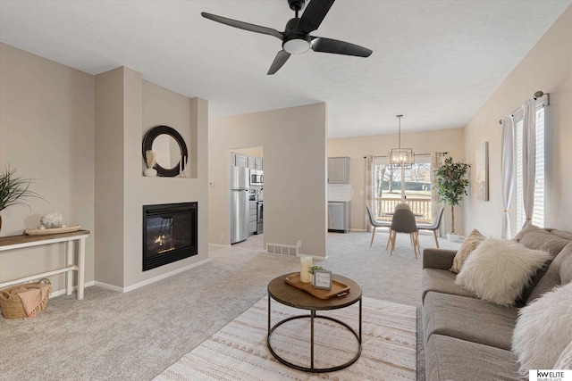 living room with light colored carpet and ceiling fan with notable chandelier