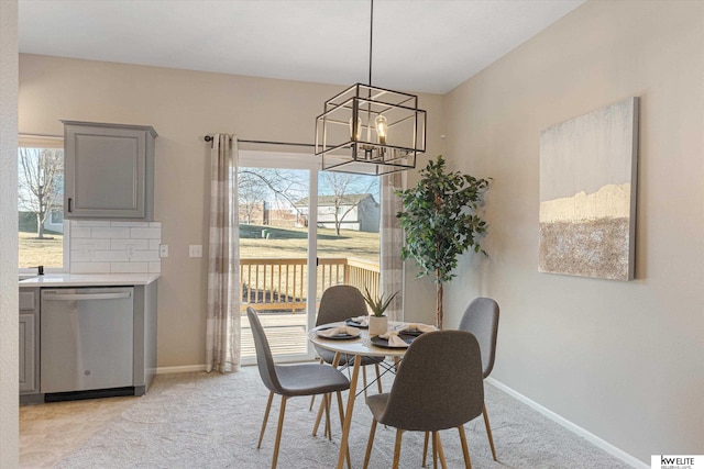 carpeted dining room with a chandelier