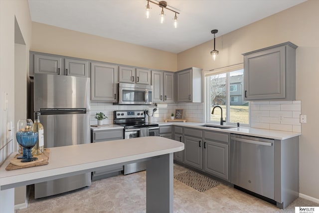 kitchen with sink, gray cabinets, stainless steel appliances, and tasteful backsplash