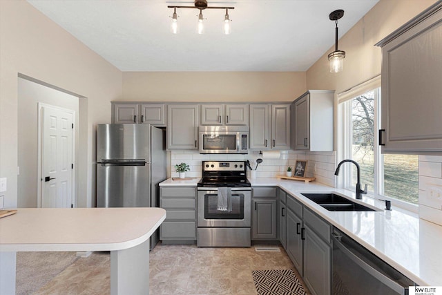 kitchen with stainless steel appliances, gray cabinetry, backsplash, pendant lighting, and sink