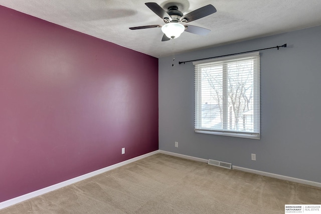 unfurnished room with light carpet, ceiling fan, and a textured ceiling