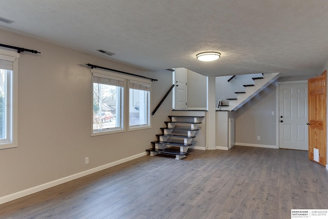 basement with a textured ceiling and light hardwood / wood-style flooring